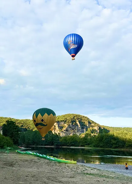 Terrasse du Snack des Pirates sur la plage de la Dordogne avec canoës et montgolfières