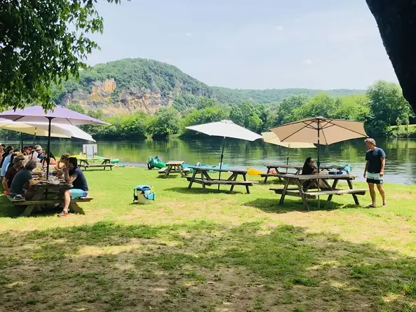 Terrasse du Snack des Pirates en bord de Dordogne avec tables de pique-nique